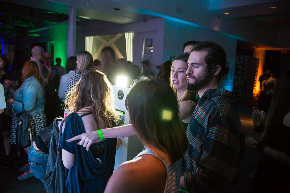Crowd mingling in the blue-lit venue during the opening party
