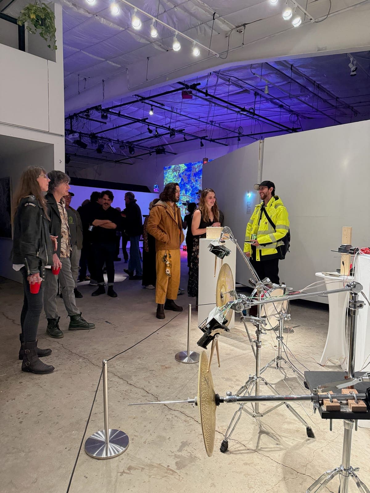 Performers and guests gathered among cymbals and stands at the opening reception