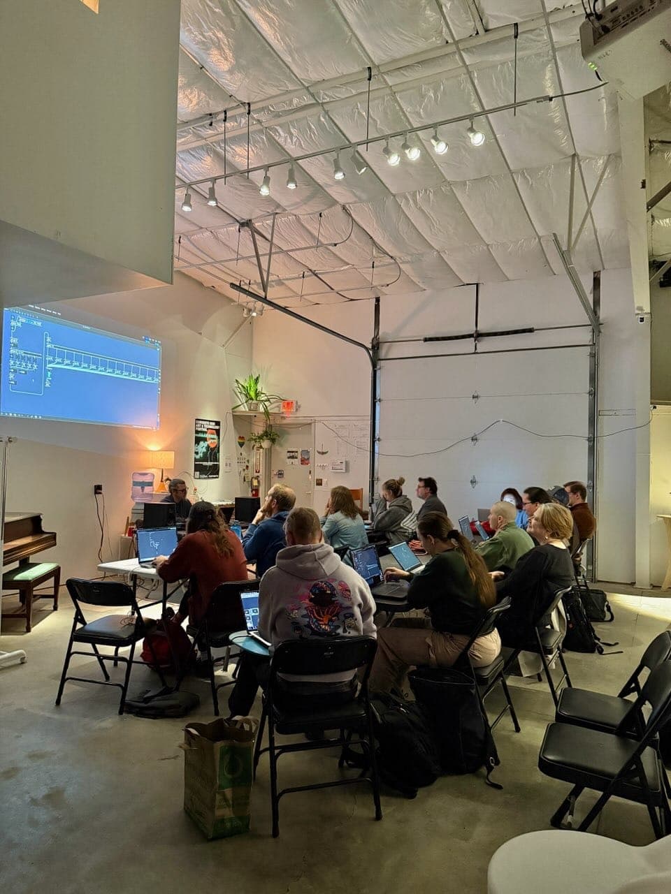 A workshop audience watching a live-coded projection in the gallery