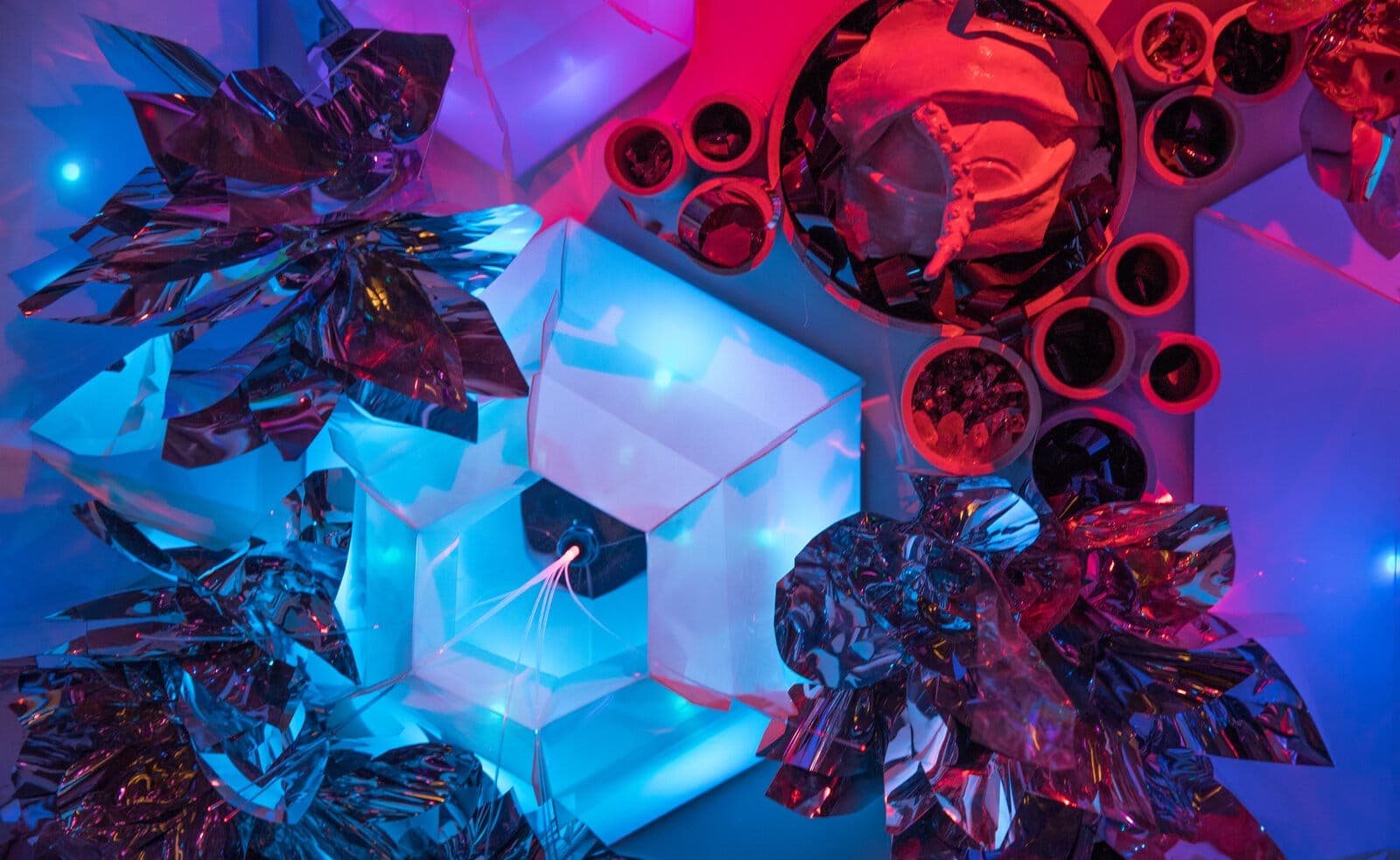 Detail: backlit hexagonal panels surrounded by iridescent mylar barnacle blooms and clustered tube colonies